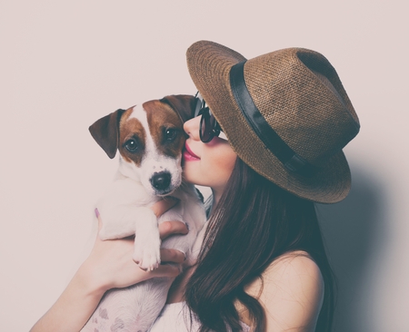 portrait of the beautiful young woman with dog on white backgroundの写真素材