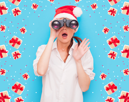 Portrait of a redhead woman with binocular on blue backgroundの写真素材
