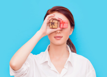 Portrait of redhead woman with two gift boxes on blue backgroundの写真素材