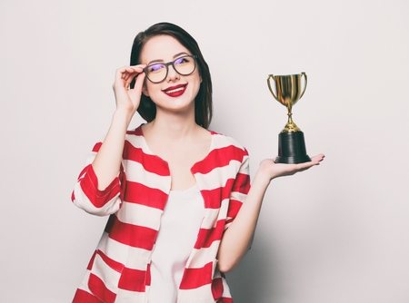 portrait of the beautiful young smiling woman with cup trophyの写真素材