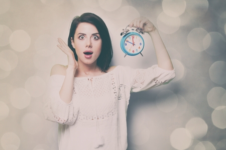 portrait of the beautiful young woman with blue clockの写真素材