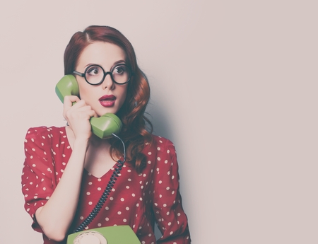 beautiful surprised young woman with retro phoneの写真素材