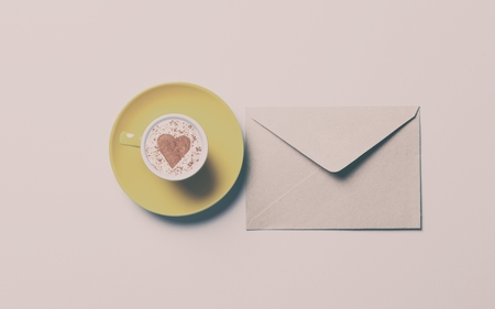 yellow cup of coffee and envelopeの写真素材