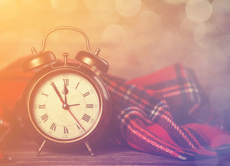 Alarm clock and scarf. Photo in retro color style.
