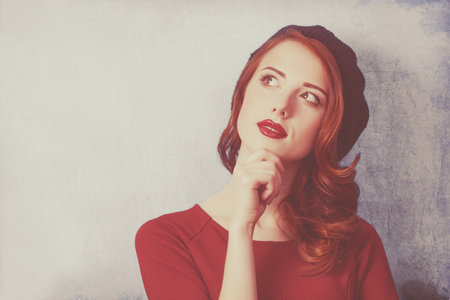 Redhead women in beret on grey background.の写真素材
