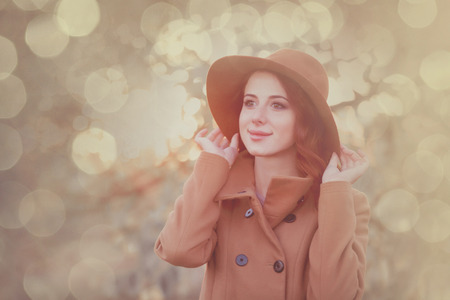 Woman in hat and coat in autumn time outdoorの写真素材