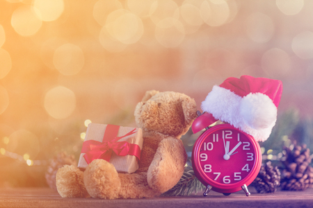 Retro alarm clock with Santa Claus hat with Christmas Fairy Ligths and Pine tree at backgroundの写真素材
