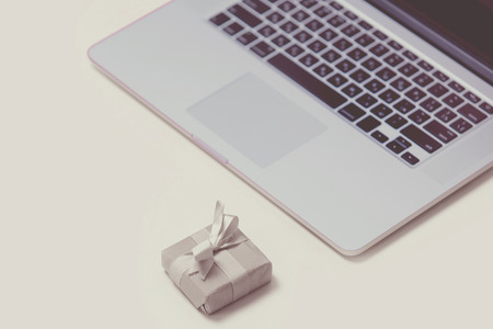 beautiful small gift and cool laptop on the wonderful pink backgroundの写真素材