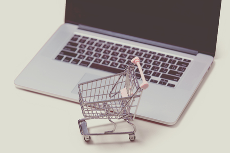 beautiful shopping cart and cool laptop on the wonderful pink backgroundの写真素材