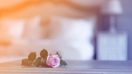 pink rose on wooden table with Fairy Ligths in bedroomの写真素材