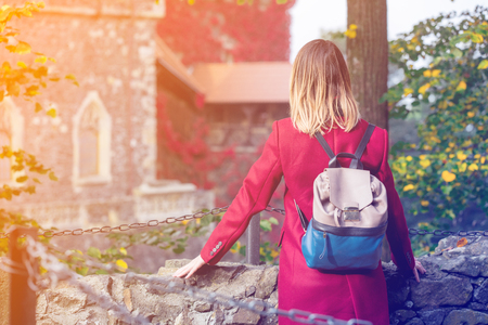 Redhead woman with backpack at castle background at autumn season time.の写真素材