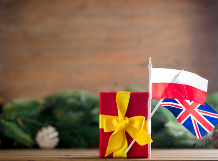 Little gift box with Poland and UK flags and pine cones and branches on background.の写真素材