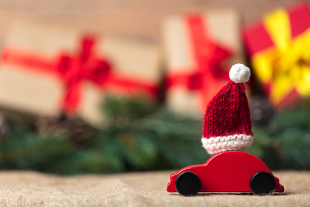 Christmas gifts and red car toy with Santa Claus hat の写真素材