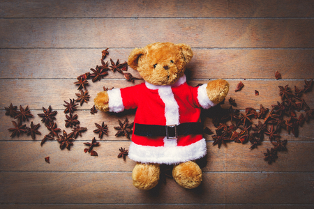 Christmas teddy bear toy and star naise on wooden backgroundの写真素材