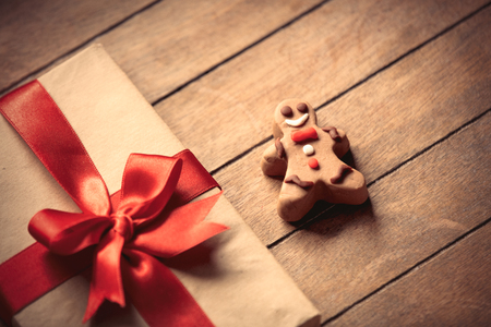 gingerbread man and Christmas gift box on wooden backgroundの写真素材