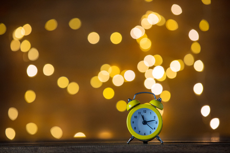 Vintage alarm clock and Fairy Lights on backgroundの写真素材