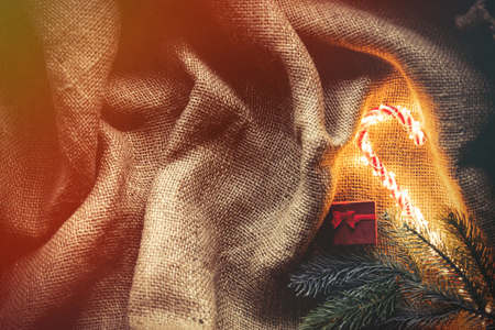 Christmas Candy cane and pine branch on jute backgroundの写真素材