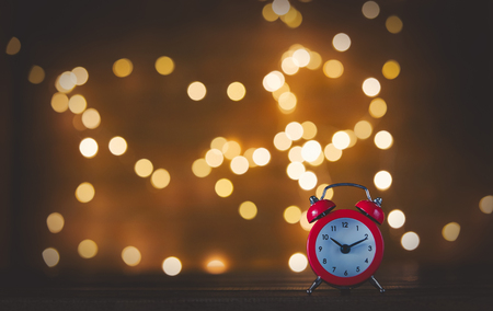 Vintage alarm clock and Fairy Lights on backgroundの写真素材