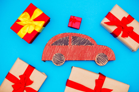 Red handmade car delivery with Christmas gift boxes on blue backgroundの写真素材