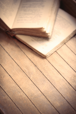 Old books on wooden table. Focus on central side of wooden tableの写真素材