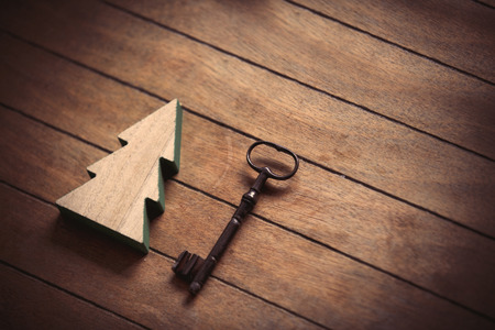Christmas tree toy and metal key on wooden backgroundの写真素材