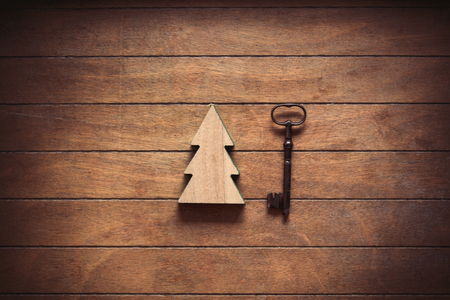 Christmas tree toy and metal key on wooden backgroundの写真素材