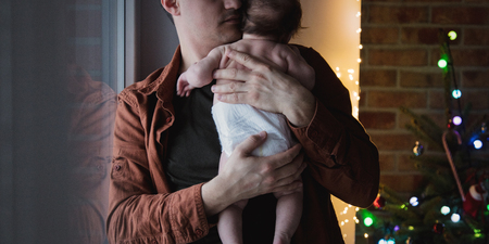 Young father holding in hands a little child in diaper. Indoor image with focus on infantの写真素材