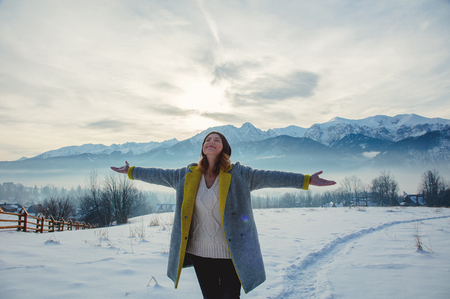 Woman with open hands relaxing at outdoor with snow mountains on backgroundの写真素材