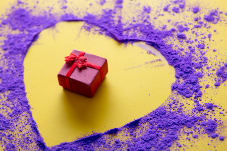 Pink and purple paint and gift box on yellow background.の写真素材