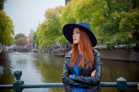 Young redhead girl in hat at streets of Amsterdam, Netherlandsの写真素材