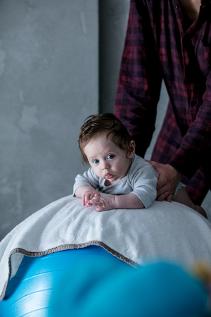 Little child lying down in fitball during morning work-out の写真素材