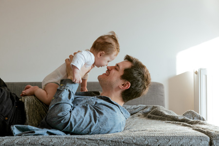 Young father and baby boy at home interior の写真素材