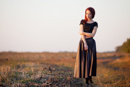 Hipster redhad girl in skirt at autumn time sunset outdoorの写真素材