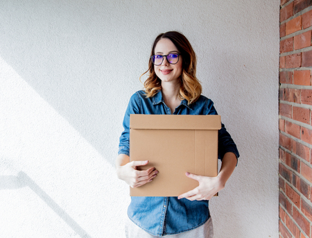 redhead girl with a box in move out day.の写真素材