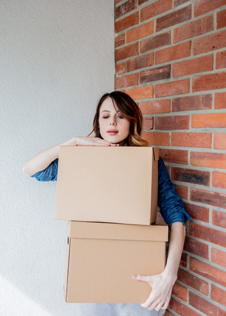 redhead girl with a box in move out day.の写真素材