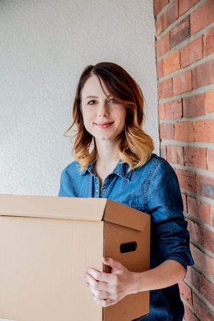 redhead girl with a box in move out day.の写真素材
