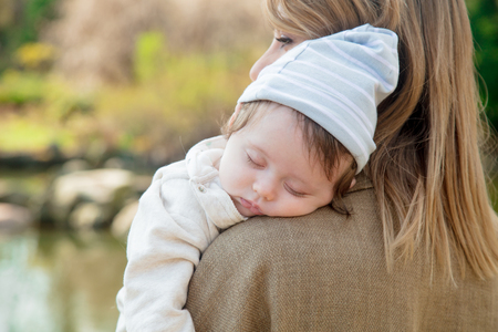Young redhead mother and little baby in springtime parkの写真素材