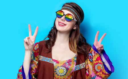 Portrait of Young hippie girl with rainbow glasses on blue backgroundの写真素材
