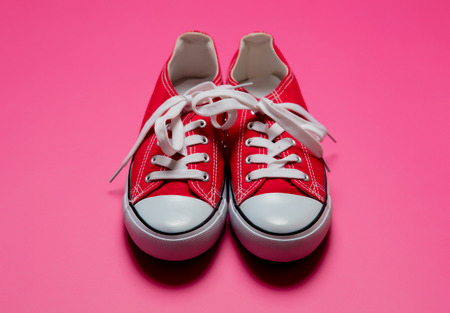 Red low-top gumshoes isolated on pink backgroundの写真素材