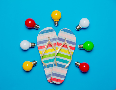 colored lightbulbs and sandals on blue background