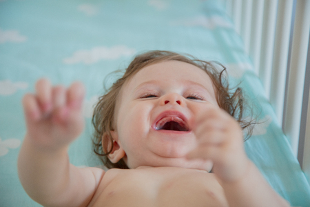 Little baby lying down in a bed at home. Image made with natural lite.の写真素材