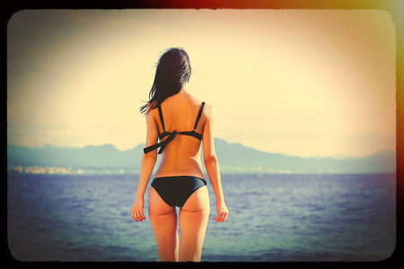 photo of the beautiful young woman on the beach resting in Greece. Image with film old frame.の写真素材