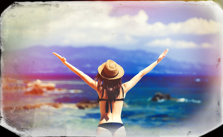 photo of the beautiful young woman standing on the beach resting in Greece . Image made with old film frame.の写真素材
