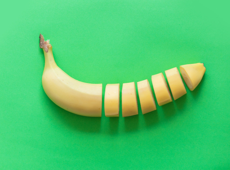 Yellow cut banana isolated on green background. Natural lightの写真素材