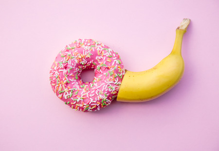 Fresh sweet donut and banana on pink background. Abive viewの写真素材