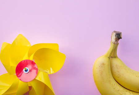 yellow banana and pinwheel on clear pink background. Above viewの写真素材