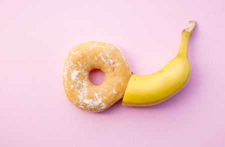 Fresh sweet donut and banana on pink background. Abive viewの写真素材