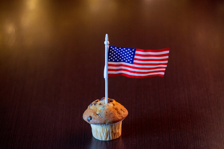 Homemade classic cupcake and flag of the United States with fairy lights in bokeh.の写真素材