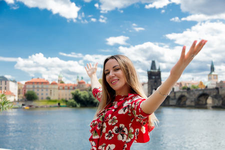 Beautiful girl in red dress travel in Prague, city streetsの写真素材