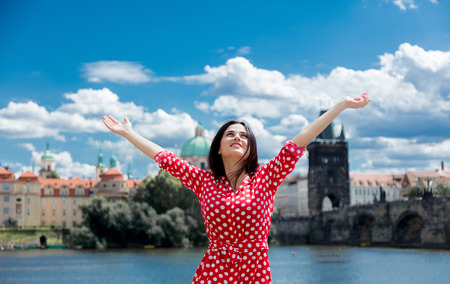 Beautiful girl in red dress travel in Prague, city streetsの写真素材
